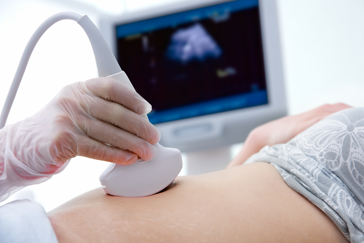 Pregnant woman getting ultrasound from doctor