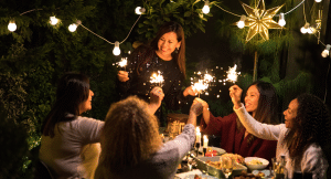 Group of women gathering for a holiday party and holding sparklers.