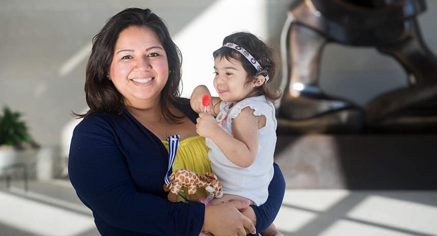Krishna Hernandez with her daughter, Bellemere , who received a cochlear implant.