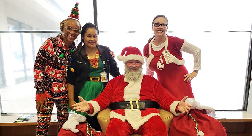 UT Physician employees dressed up as Santa and his elves at a holiday party