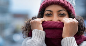woman wears hat and scarf for cold weather