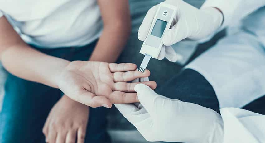 doctor testing blood sugar level on patient