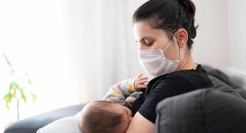 masked mom breastfeeding baby