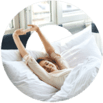 Woman stretching in bed after waking up