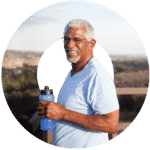 Man holding a water bottle with landscape behind him