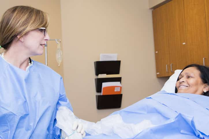 Female doctor performing procedure on woman for varicose veins