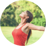 Woman in field holding arms out and soaking up the sun