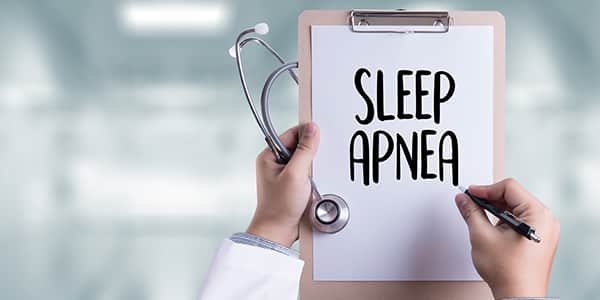 Doctor holding a clipboard with "Sleep Apnea" written on it