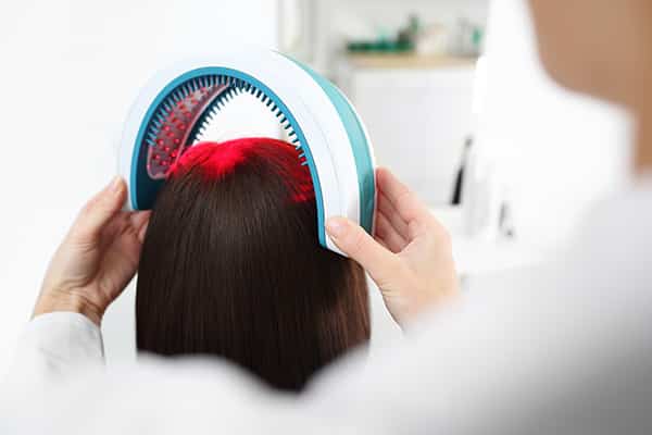 Doctor Placing a Laser Device on a woman's head