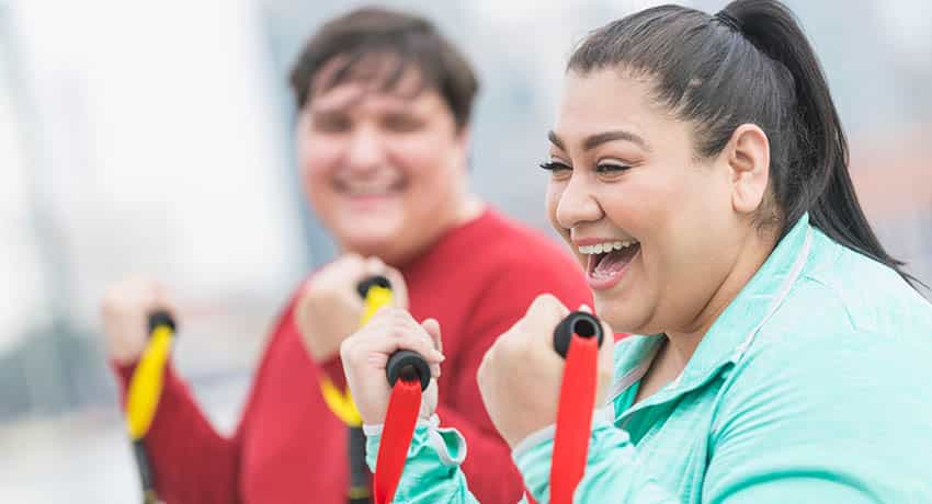 Woman laughing while working out with a man