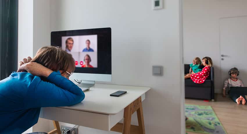 burned out father attending virtual meeting with kids in background