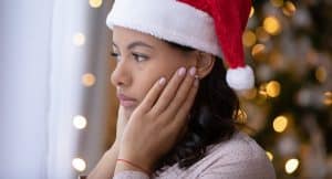 Sad woman looking out the window during holiday season