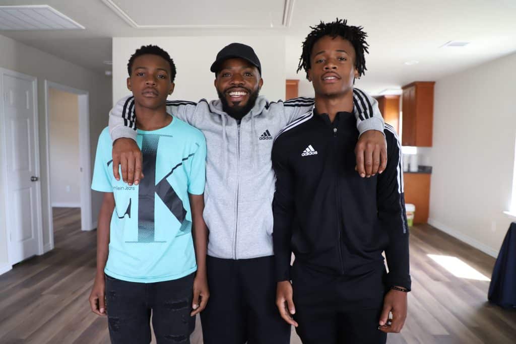 Jacoby George (middle) poses in his new home with his two sons, Jacoby Jr. (right) and Jacob (left).