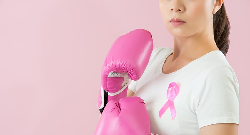 Woman in pink boxing gloves sports breast cancer awareness ribbon
