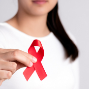 Woman holds up HIV Awareness Month ribbon
