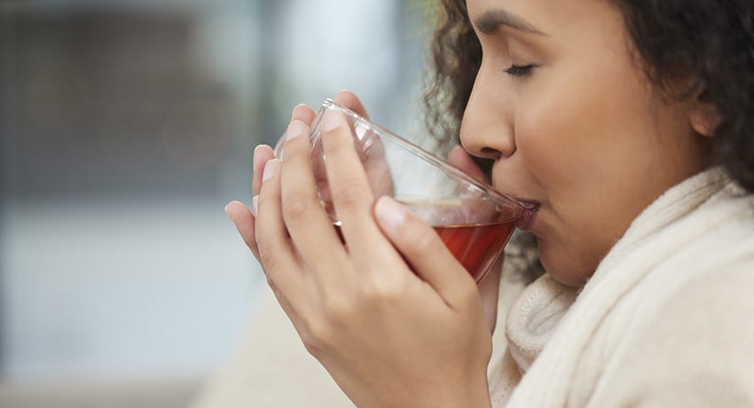 Woman sips a hot cup of tea on a cold day