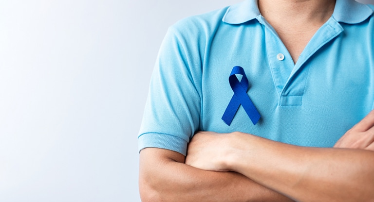 Person wears blue ribbon to raise colorectal cancer awareness