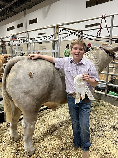 Eli Wise poses with his steer and third-place ribbon for the Junior Market Steer Show at the Houston Livestock Show and Rodeo