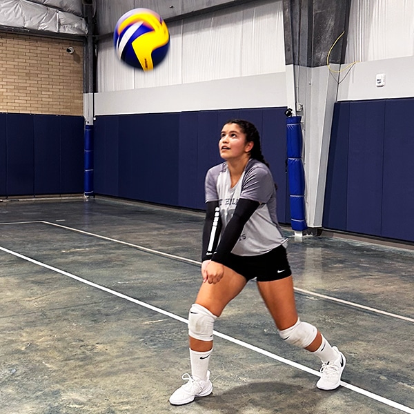 Gizelle passing volleyball on the court