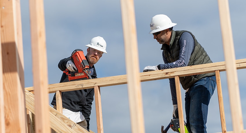 Two UT Physicians providers helping to build a Habitat home frame
