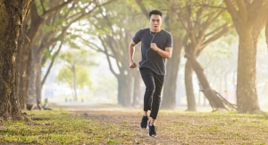 Man running with proper form on an outdoor trail