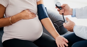 Pregnant woman checking blood pressure in a doctor's office