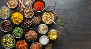 Colorful herbs and spices for cooking. Indian spices. On grey stone background. Top view.