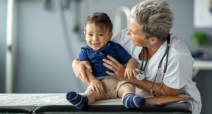 A cheerful toddler being comforted by a caring doctor during a pediatric checkup.