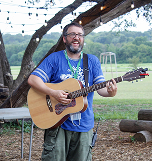 Mike Mason playing guitar at an outdoors venue