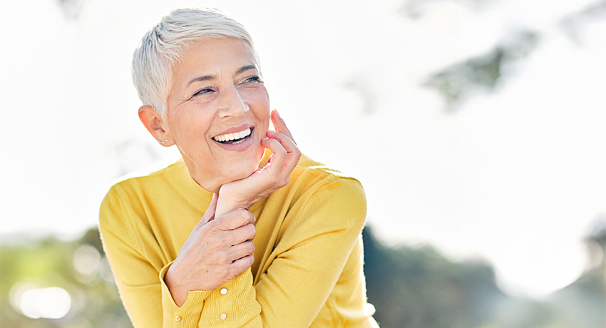 Portrait of an elderly woman outdoors. Happy senior woman in park