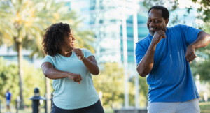 Mature multiracial couple have fun dancing outdoors