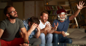 Four friends watching football game on television
