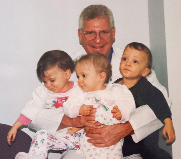 Dr. Katz holding the Haidar family triplets
