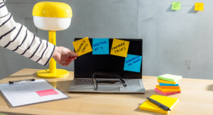 laptop in a workspace setup with colored sticky notes to help manage ADHD at work