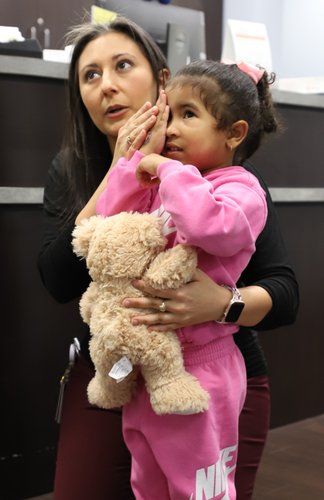 Stephanie Handal is working with a young child during an eye exam at the UTHealth Houston Cares event.