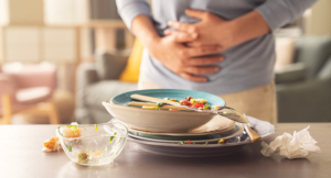 A person holding their stomach due to bloating and stomachache