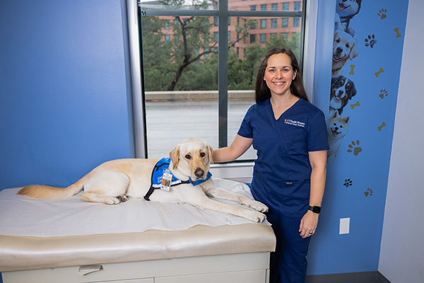 Rachel poses with Boris that dog in a clinic exam room